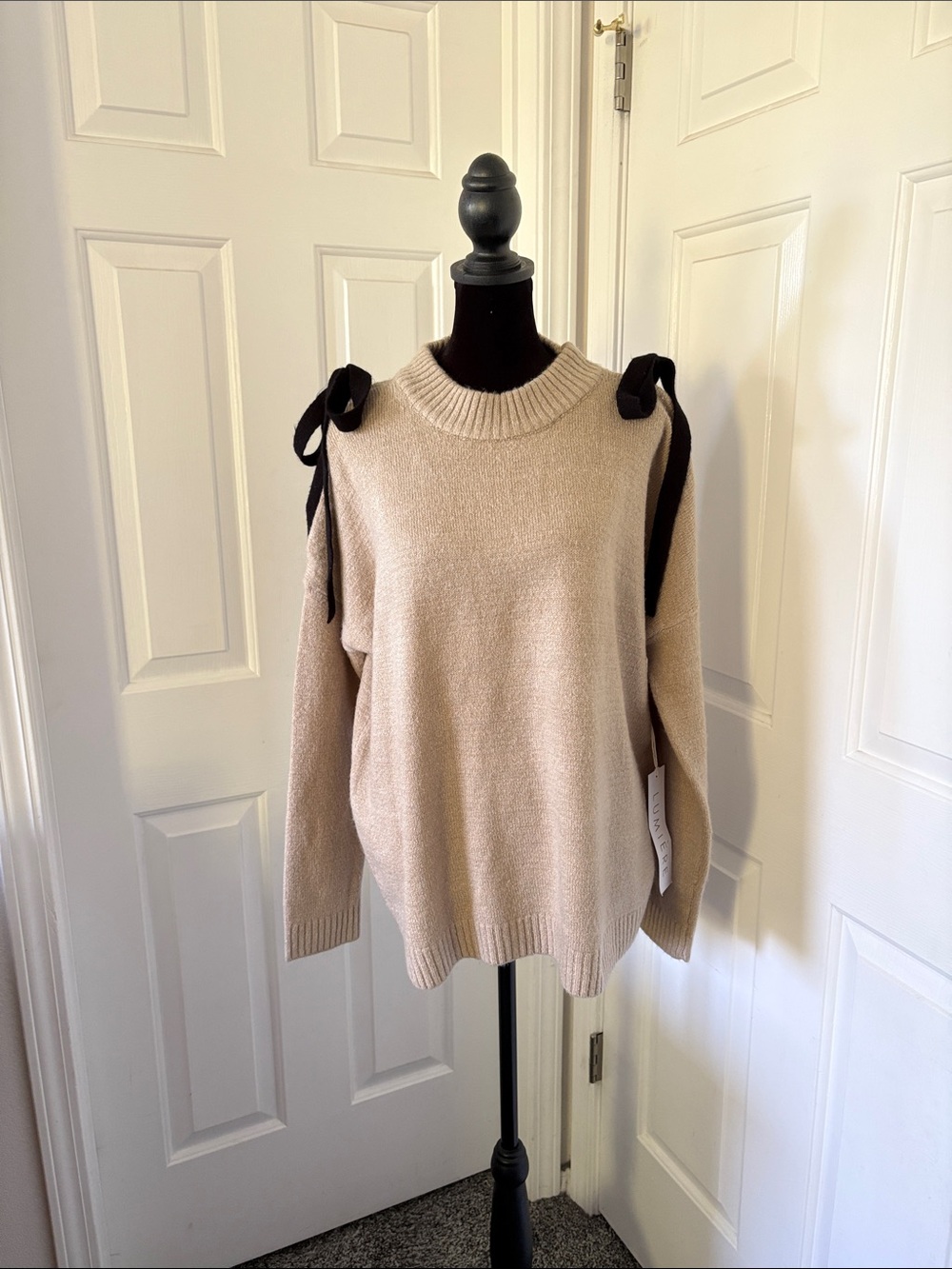 Lumiere’s Beige Cold-Shoulder Knit Sweater with Black Tie Details